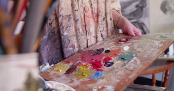 Фарба покрита руками художника, що тримає пензлі — стокове відео