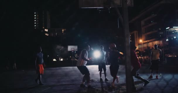 Jogadores de basquete jogando na corte durante a noite — Vídeo de Stock