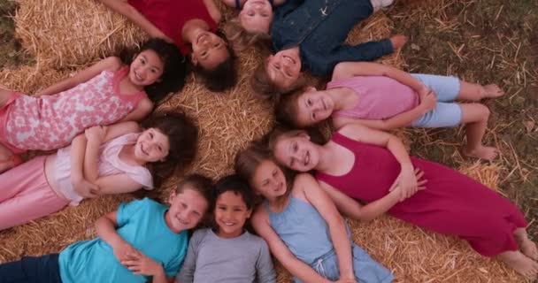 Grupo de niños acostados en círculo sobre paja — Vídeo de stock