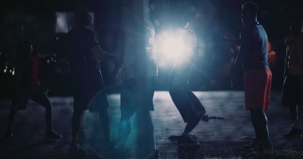 Jugadores de baloncesto jugando en la cancha durante la noche — Vídeos de Stock