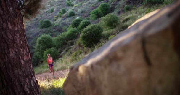 Jogger luisteren naar oortelefoons op een berg lopend parcours — Stockvideo