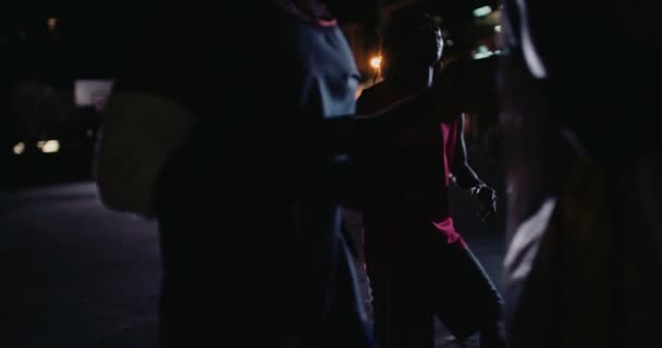 Jugadores de baloncesto jugando en la cancha durante la noche — Vídeos de Stock