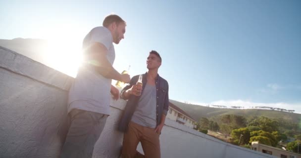 Zwei Freunde trinken bei Sonnenuntergang auf dem Dach — Stockvideo