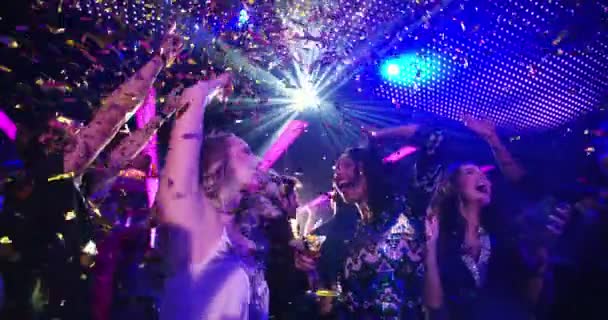 Partygirls tanzen und lachen mit Konfetti in Nachtclub. — Stockvideo