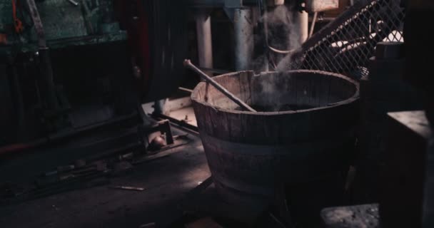 Hierro al vapor enfriándose en el barril de agua del taller de herrería — Vídeo de stock