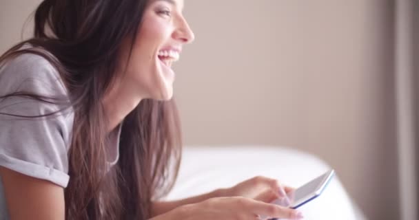 Mulheres deitadas na cama estão usando seu tablet — Vídeo de Stock