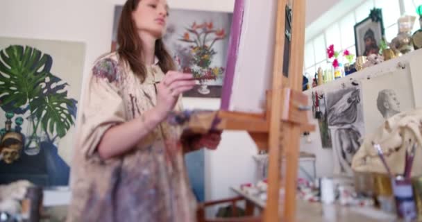 Artist painting on canvas with brush in her studio — Stock Video