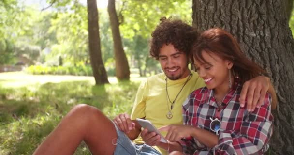 Pareja de mensajes de texto en el Smartphone Juntos en el parque — Vídeos de Stock