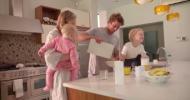 Family Standing and Having Breakfast in Kitchen
