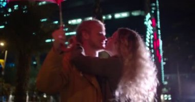 Şehirdeki bir şemsiye altında öpüşme Çift