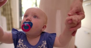 Anne bebek kızı ilk adımlarını atıyor yardımcı olur.