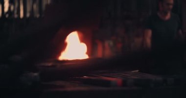 Arka planda çalışan demirci ile parlayan demir