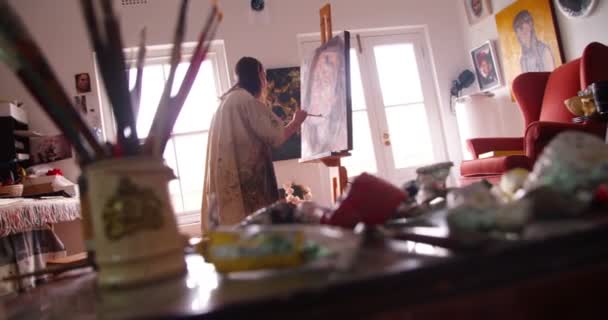 Художник пишет автопортрет на холсте — стоковое видео