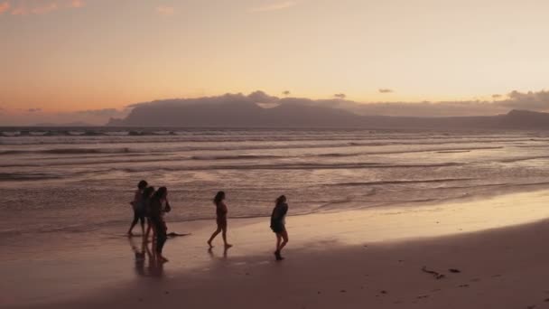 일몰에 해변에서 산책을 즐기는 친구 — 비디오