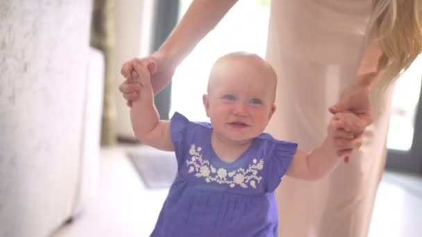 Maman aide la petite fille à faire les premiers pas — Video