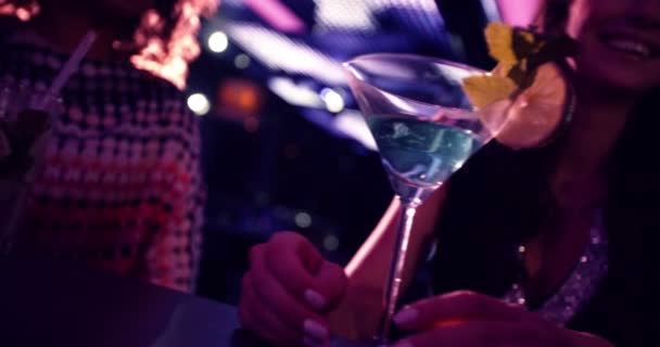 Partygirls stoßen fröhlich auf Martinis im Nachtclub an
