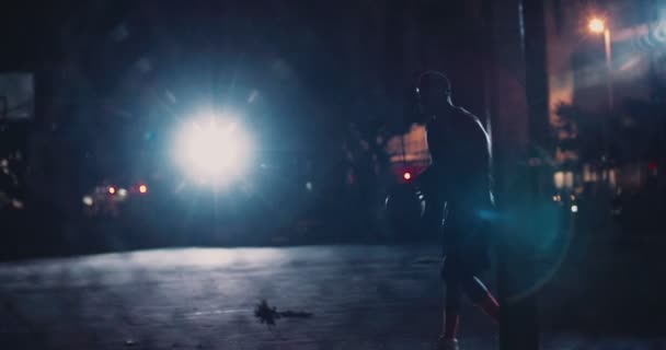 Баскетболист тренируется в одиночестве на корте ночью — стоковое видео