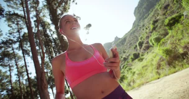 女性の屋外の実行の準備ができて電話を使用して — ストック動画