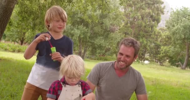 Padre e hijos se divierten con burbujas de jabón — Vídeos de Stock