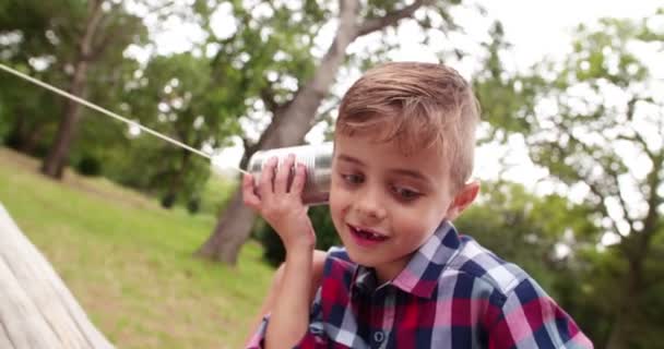 Menino ouvindo na lata telefone — Vídeo de Stock