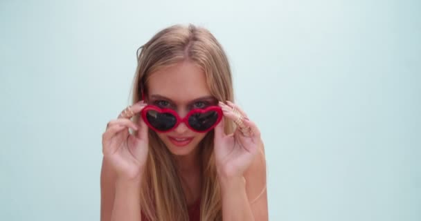 Blonde adolescente avec des lunettes de soleil coeur — Video