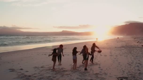 Teen vänner dansa på stranden vid solnedgången — Stockvideo