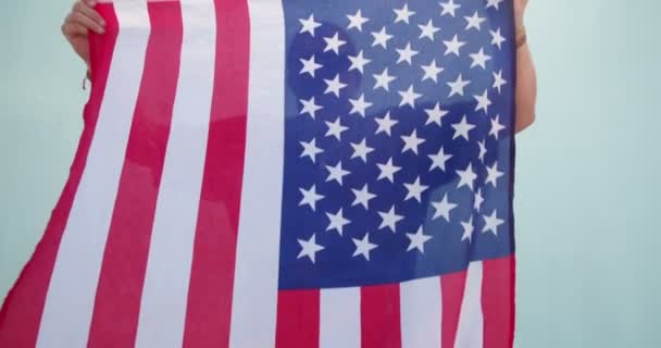 Amerikanischer Patriot posiert und versteckt sich hinter Flagge — Stockvideo