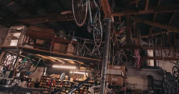 Bicicleta pendurada por corda de vigas em uma garagem — Vídeo de Stock