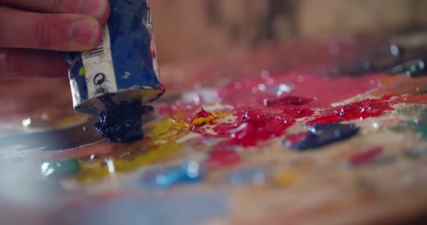 Різнокольорові фарби на палітрі, змішані з ножем — стокове відео