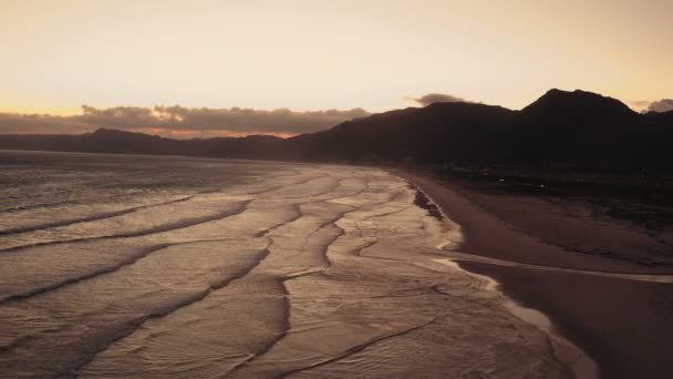 Luchtfoto van een strand bij zonsondergang — Stockvideo