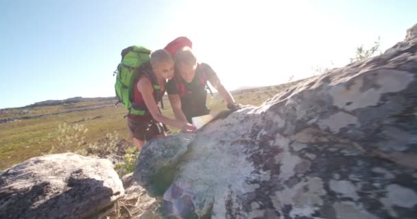 Hiker couple using compass and map — Stock Video