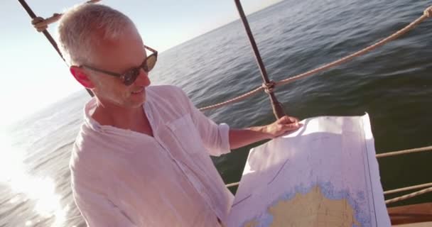 Viajero en velero mirando el mapa y sonriendo — Vídeos de Stock