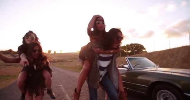 Vrienden doen piggyback ritten op landweg — Stockvideo