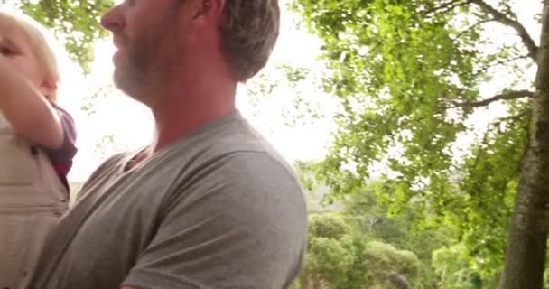 Papá llevar a su hijo riendo en sus brazos fuera — Vídeo de stock