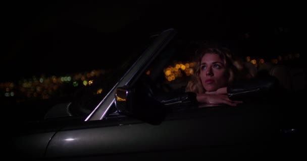 Girl enjoying night city lights from a convertible — ストック動画