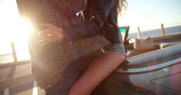 Pareja abrazando al atardecer en convertible — Vídeos de Stock