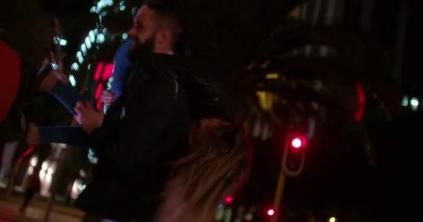 Хлопець піднімає свою дівчину вночі в місті — стокове відео