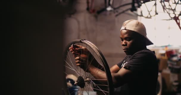 Meccanico per biciclette che fissa una ruota in un'officina di riparazione — Video Stock