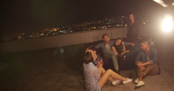 Jóvenes amigos pasando el rato en un sofá en la azotea — Vídeos de Stock