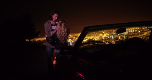 Casal abraçando e olhando para luzes da cidade noite — Vídeo de Stock