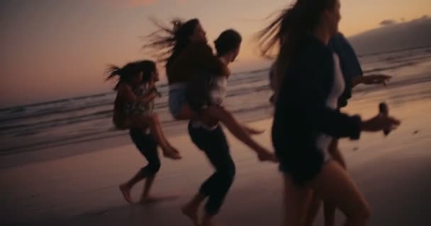Przyjaciele robi śmieszne piggyback jeździ na plaży — Wideo stockowe