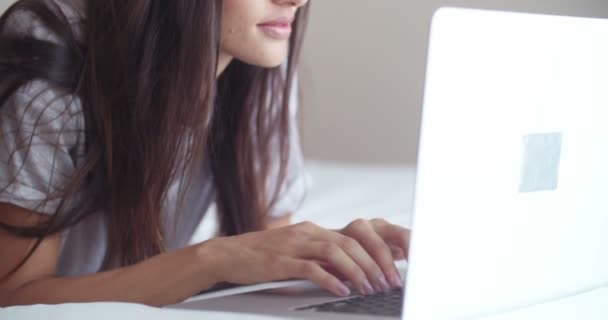 Mujer en la cama está utilizando su ordenador portátil — Vídeos de Stock