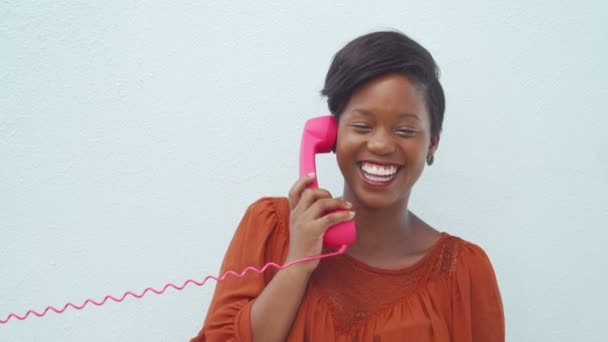 Lachende vrouw praten over de roze telefoon — Stockvideo