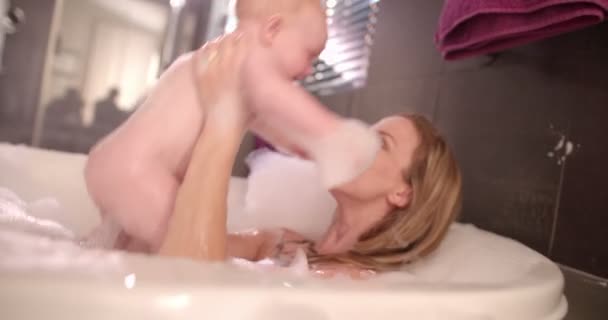 Maman prend un bain moussant avec une fille infantile — Video