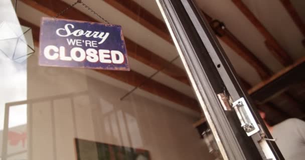 Человек-хипстер поворачивает вывеску на двери кофейни — стоковое видео