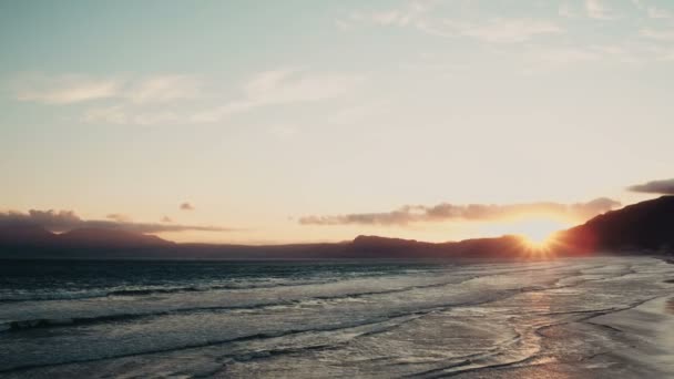 Vista aérea de uma praia ao pôr do sol — Vídeo de Stock