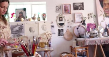 Sanatçı, stüdyosunda palet bıçağıyla boya yıkarıştırıyor