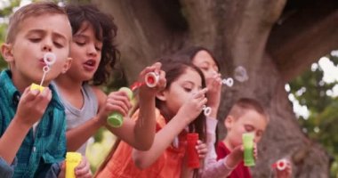 kabarcıklar üfleme arkadaşlarıyla eğleniyor çocuk