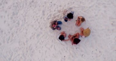 Sandy Beach üzerinde oturan hipster arkadaşlar