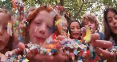 Çocukların Konfetiler açık havada bir parkta üfleme